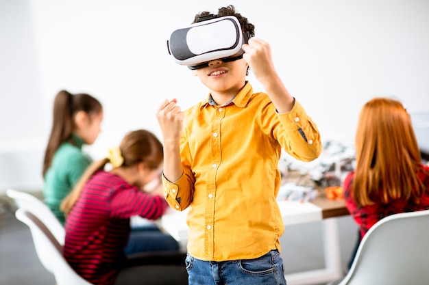 Śliczny mały chłopiec w okularach wirtualnej rzeczywistości VR w klasie robotyki