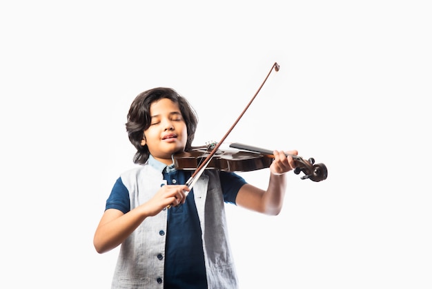 Śliczny mały indyjski muzyk azjatycki chłopiec grający na skrzypcach muzyczny instrument strunowy na białym tle