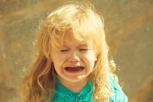 Zdjęcie Śliczny nieszczęśliwy chłopiec płacze