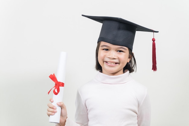 Śliczny szczęśliwy azjatycki absolwent szkoły z kapeluszem ukończenia szkoły i dyplomem na białym tle