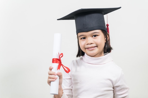 Śliczny szczęśliwy azjatycki absolwent szkoły z kapeluszem ukończenia szkoły i dyplomem na białym tle