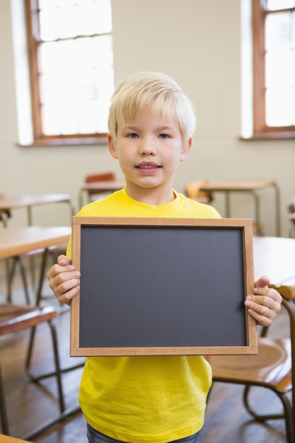 Śliczny ucznia mienia chalkboard w sala lekcyjnej