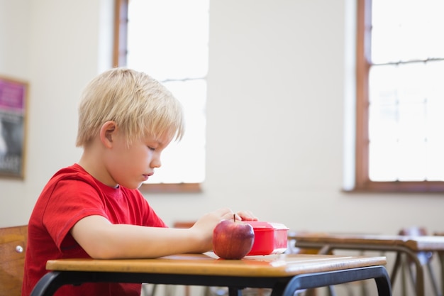 Śliczny Ucznia Otwarcia Lunchbox Przy Biurkiem W Sala Lekcyjnej