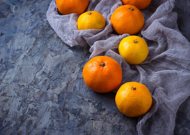 Słodcy pomarańczowi tangerines na betonowym tle. Selektywne skupienie