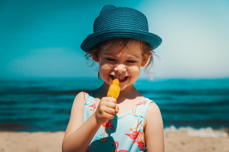 Zdjęcie słodka dziewczyna oddala się, jedząc lody na plaży.