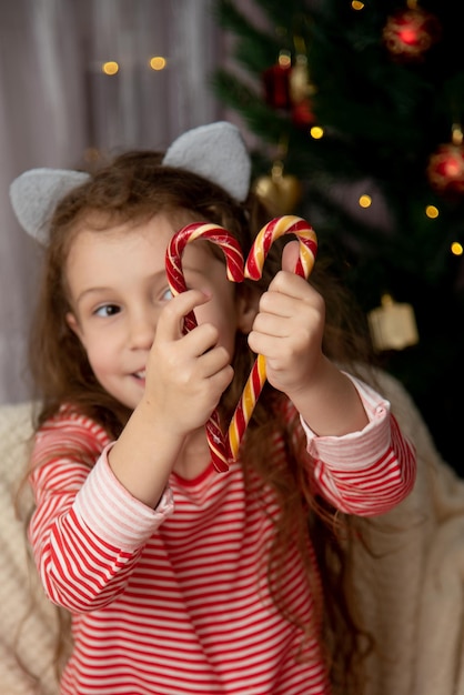 Słodka dziewczyna trzyma słodycze w kształcie serca Nowy rok Strona główna