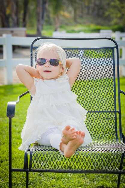 Słodka dziewczynka w okularach przeciwsłonecznych na zewnątrz w parku