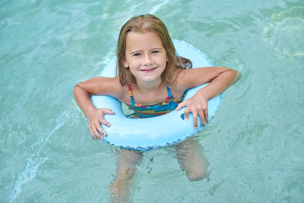 Słodka mała dziewczynka pływająca na rurce i uśmiechnięta