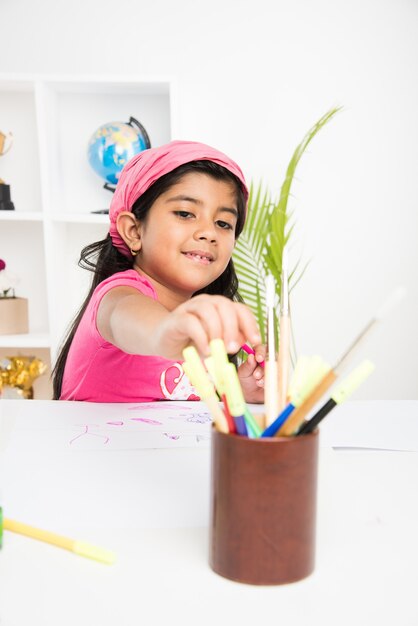 Słodka Mała Indyjska Lub Azjatycka Dziewczynka Lubi Rysować Lub Malować Pędzlem I Malować Na Papierze W Domu