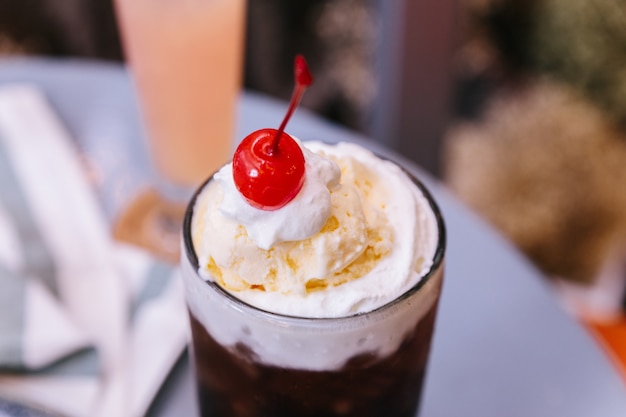 Słodka orzeźwiająca czereśnia Cherry Cola z gałką lodów waniliowych i świeżą wiśnią.