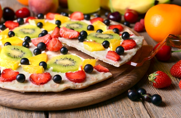 Zdjęcie słodka pizza z owocami na stołowym zbliżeniu
