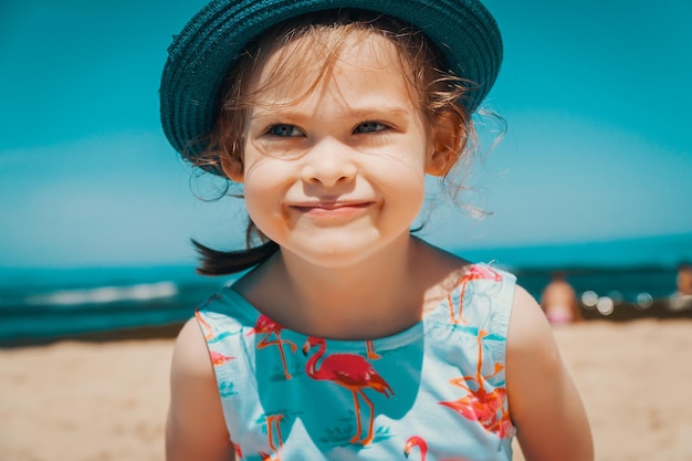 Słodka, uśmiechnięta dziewczyna patrząca na plażę.