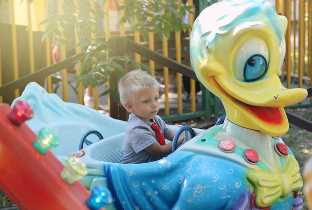 Zdjęcie słodki chłopiec bawiący się zabawką na placu zabaw.