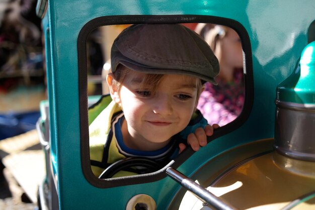 Zdjęcie słodki chłopiec cieszy się przejażdżką w parku rozrywki.