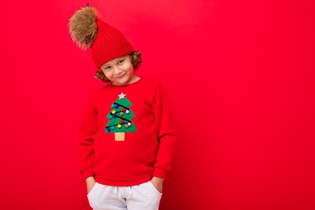 Słodki chłopiec w świątecznym swetrze i czapce