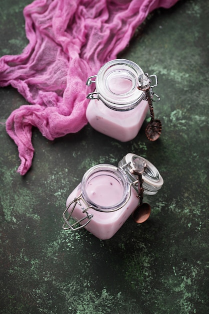 Słodki jogurt z jagodami w szklanych słoikach