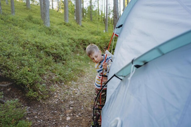 słodki, mały, kaukaski chłopiec rozbijający namiot Koncepcja rodzinnego kempingu