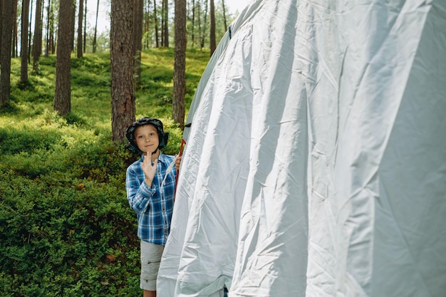 Słodki mały kaukazyjski chłopiec stawiający namiot Koncepcja kempingu rodzinnego Obraz z selektywnym fokusem
