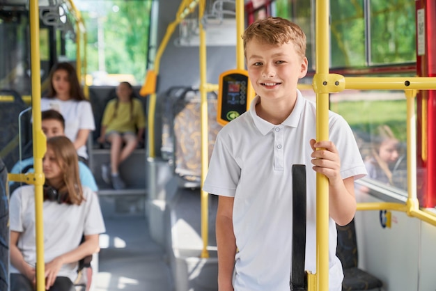 Słodki nastolatek jedzie autobusem miejskim podczas letnich wakacji