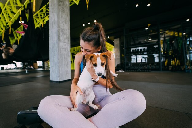 Słodki pies jack russell na siłowni z kobietą właścicielką