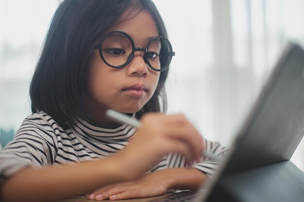 Zdjęcie słodkie azjatyckie dziewczynki korzystające z laptopa uczące się za pośrednictwem systemu e-learningu online