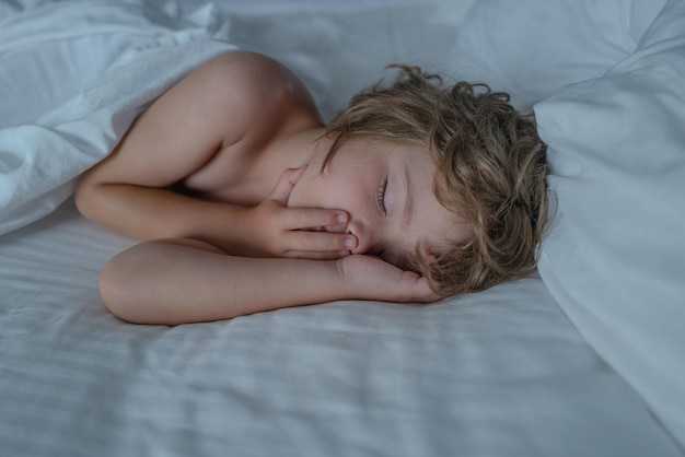Słodkie dzieci śpiące w łóżku zbliżenie portret śpiącego małego chłopca mały anioł sny