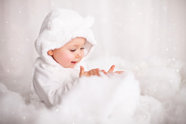 Zdjęcie słodkie dziecko bawi się watą jako sztucznym śniegiem