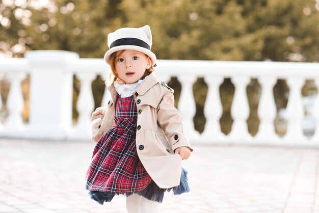 Słodkie dziecko dziewczyna nosi stylowe ubrania na tle miasta