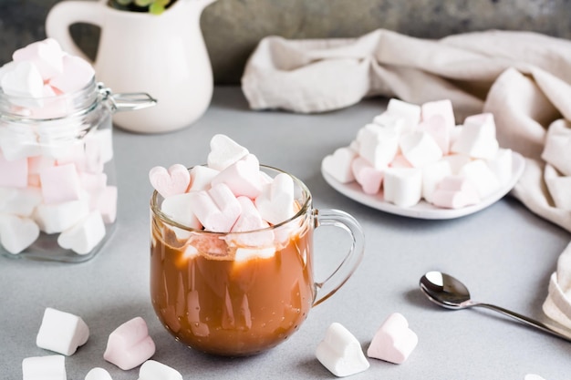 Zdjęcie słodkie kakao z piankami w kształcie serca w filiżance i na spodku na stole domowe napoje
