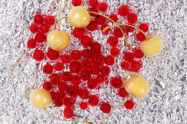 Słodkie soczyste czerwone porzeczki i żółte wiśnie na tle folii Widok z góry Koncepcja żywności wegetariańskiej