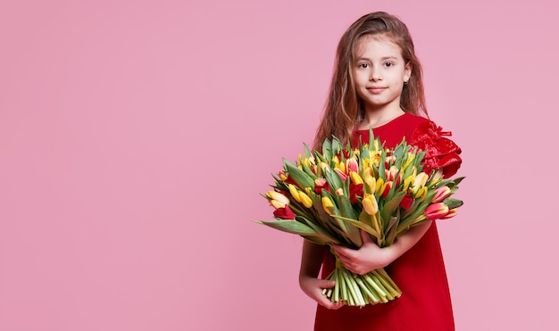 Słodkie uśmiechnięte dziecko dziewczyna trzyma bukiet wiosennych kwiatów