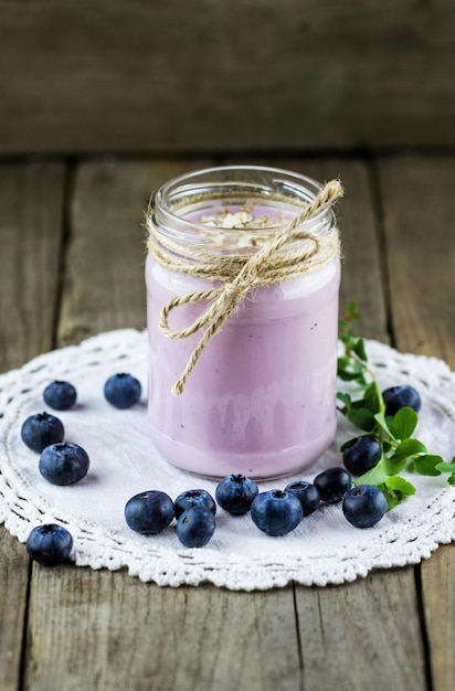 Słoik ręcznie robionego jogurtu jagodowego ze świeżymi jagodami