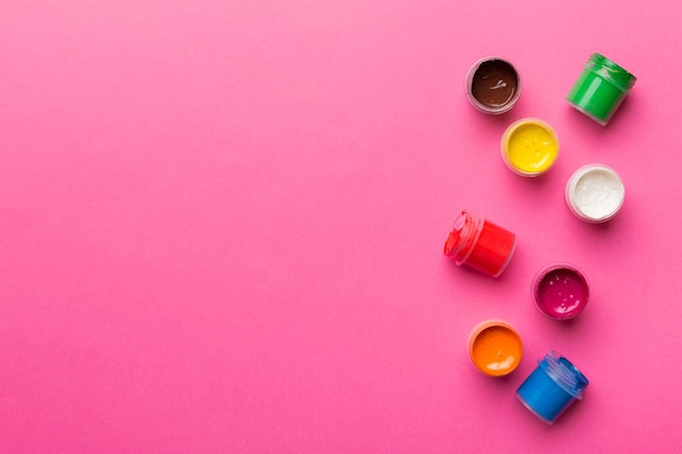 Słoiki z gwaszem w różnych kolorach na kolorowym tle malowanie hobby Widok z góry z pustą przestrzenią w miejscu pracy dla kreatywności koncepcja nauczania domowego rysunek
