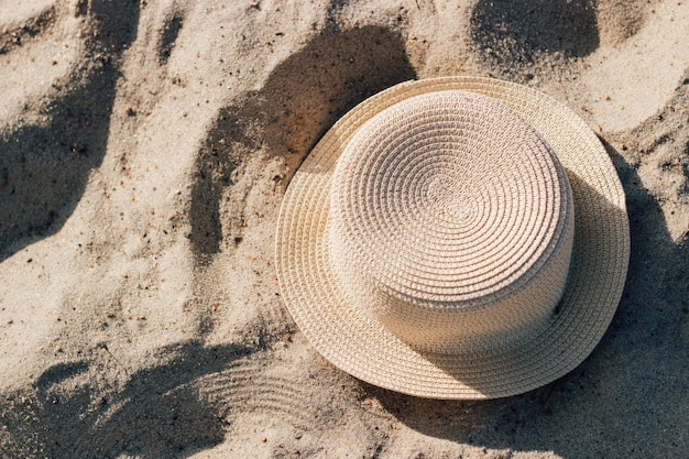Słomkowy kapelusz plażowy z rondem chroniącym przed słońcem na piasku