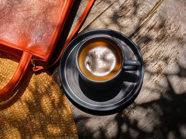 Słomkowy kapelusz pomarańczowa torebka i pyszna kawa na drewnianym stole
