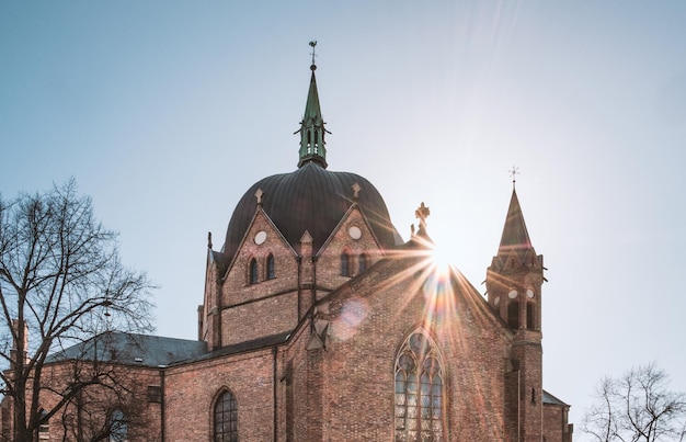 Zdjęcie słońce na zabytkowym kościele z czerwonej cegły trójcy w oslo