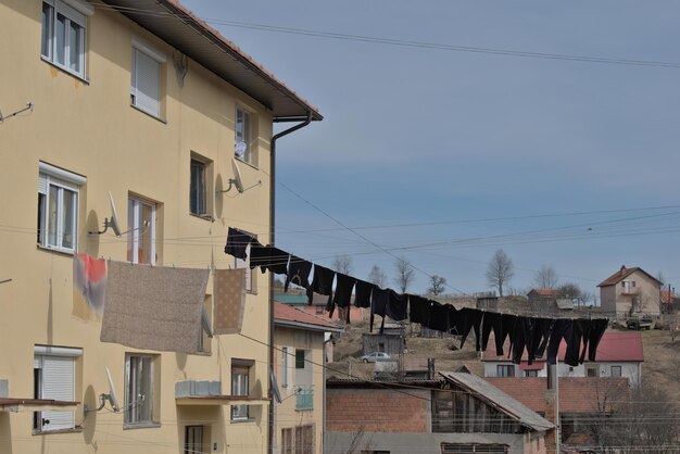 Zdjęcie słońce suszy czarne ubrania przed budynkiem mieszkalnym w wiosce