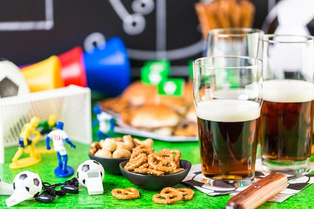 Słone przekąski i piwo na stole na imprezę piłkarską.
