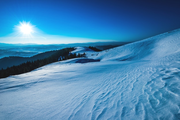 słoneczna panorama stoków narciarskich na tle doliny i wzgórz