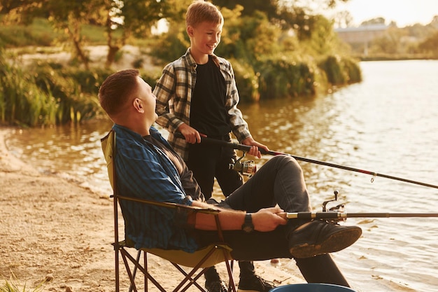 Słoneczna pogoda Ojciec i syn podczas wspólnego łowienia ryb na świeżym powietrzu w okresie letnim