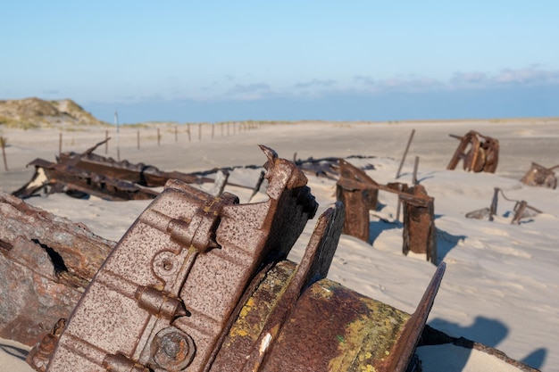 Zdjęcie słoneczny dzień z wrakami statków na piaszczystej plaży w norderney