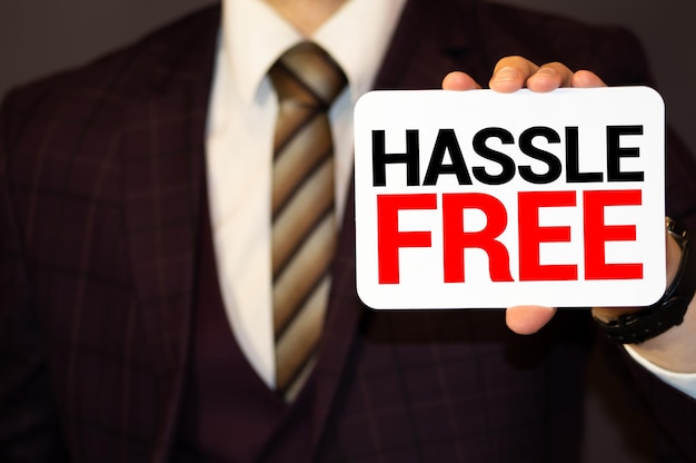 Słowa "Hassle Free" w czerwonym tekście na kartce przypiętej do tablicy ogłoszeń