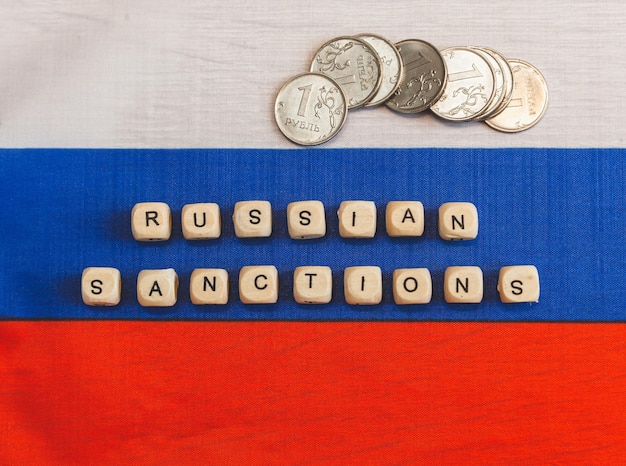 Słowa sankcje wobec Rosji są napisane z liter drewnianych kostek