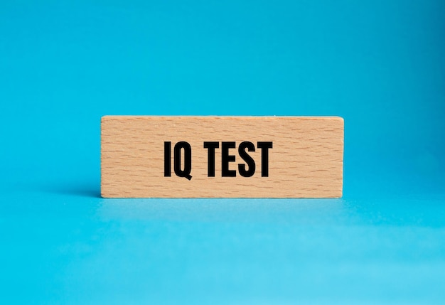 Zdjęcie słowa testu iq napisane na drewnianym bloku na niebieskim tle symbol koncepcyjny kopiuj przestrzeń