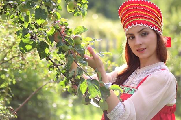 Słowianka w tradycyjnym stroju zbiera plony jabłek