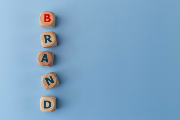 Słowo BAND na drewnianych kostkach na niebieskim tle Koncepcja biznesowa Koncepcja tożsamości marki lub świadomości