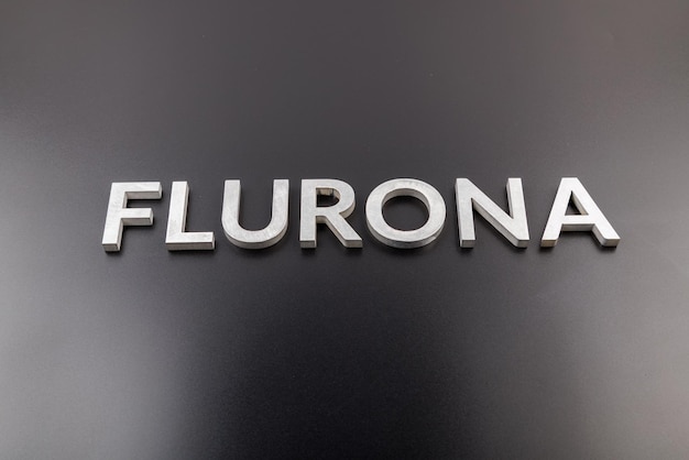 Zdjęcie słowo flurona ułożone srebrnymi metalowymi literami na błyszczącym czarnym tle prawdziwe zdjęcie