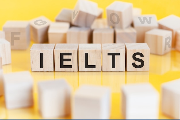 Słowo IELTS jest napisane na drewnianej konstrukcji z kostek Edukacja, koncepcja finansowa. IELTS - International English Language Testing System