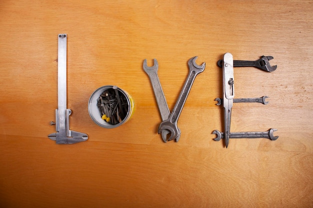 Słowo Miłość jest ułożone z narzędzi hydraulicznych na drewnianym tle