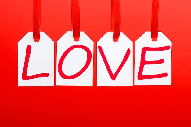 Słowo „miłość” jest zapisane w białych znacznikach na czerwonym tle.